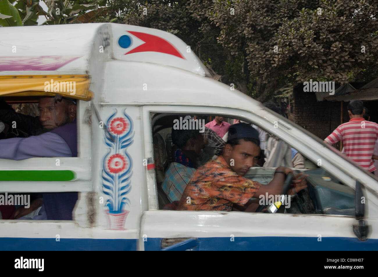 Mann fährt einen van durch bebauten Straßen in Daka, Bangladesch Stockfoto