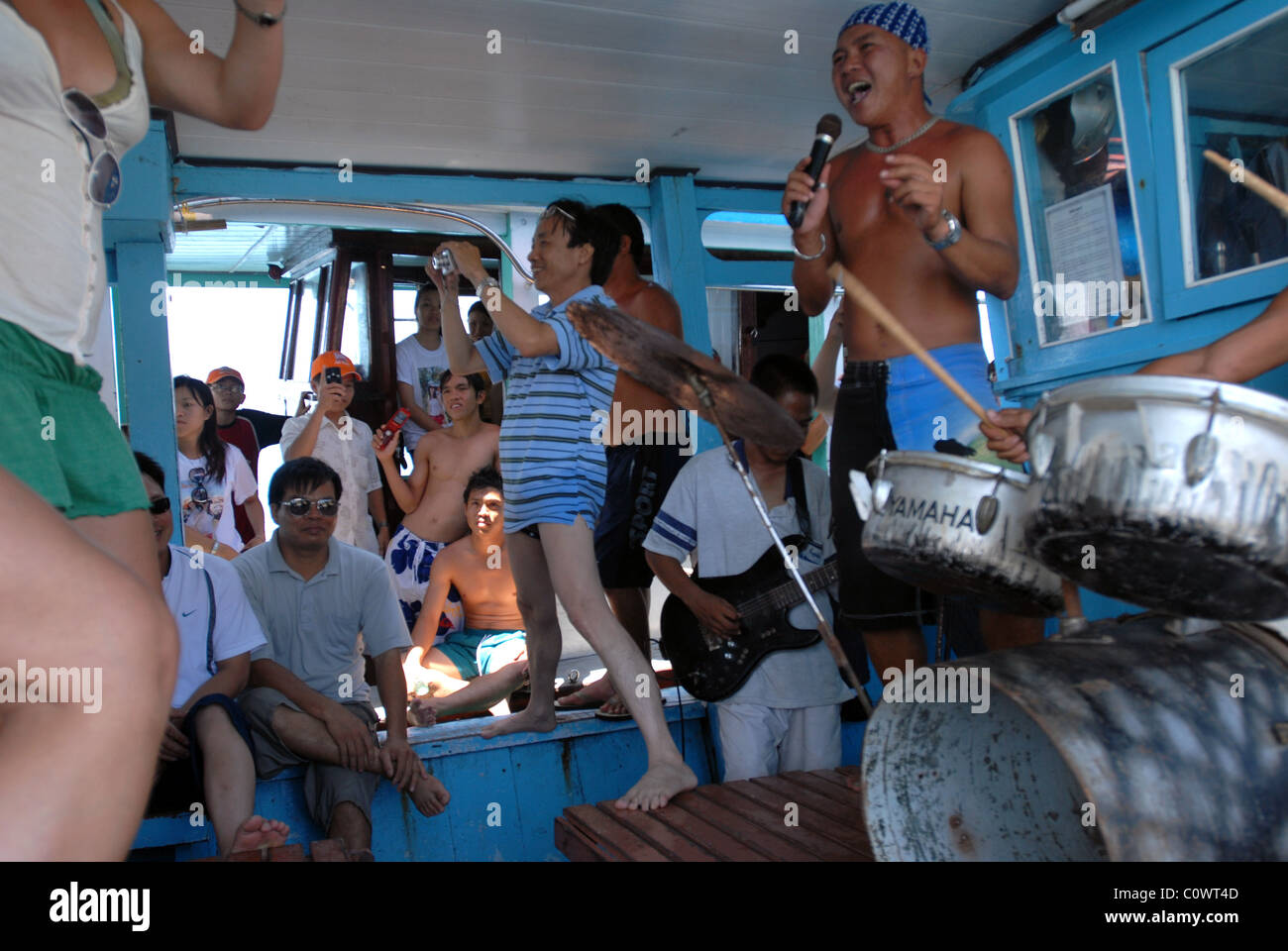 Touristen, die tanzen auf einem Boot während eines Tages Reise nach Nha Trangs vorgelagerten Inseln. Band spielt. Vietnamesen auf ein anderes Boot Stockfoto