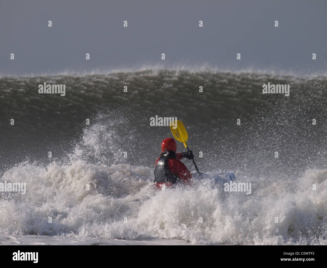 Surf-Kajakfahrer mit Blick auf eine große Welle, Devon, UK Stockfoto