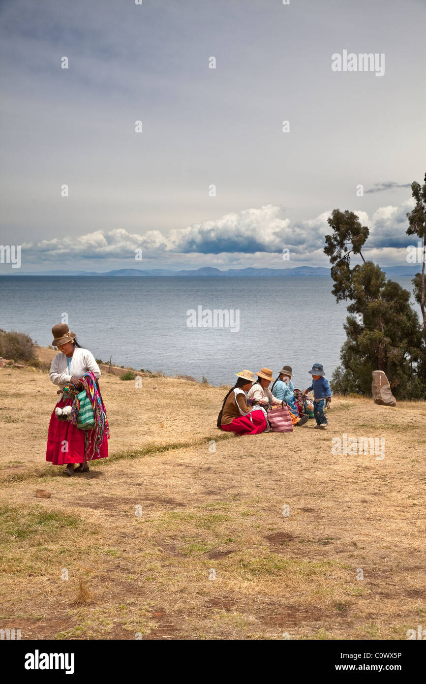 Ansichten des Titicacasees von Moon Island mit einheimischen Frauen verkaufen Souvenirs, Bolivien, Südamerika. Stockfoto