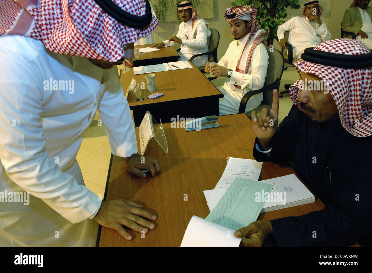 Ein Wähler bekommt Zeiger von einem stimmberechtigten Beamten bei der Baladiya Abstimmung Station in Riad in Kommunalwahlen Rat, Saudi Stockfoto