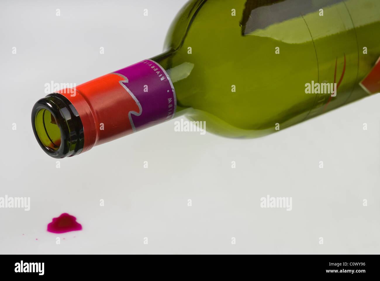 Leere Flasche Wein auf die Seite, ein Tropfen Rotwein auf dem Boden liegend. Stockfoto