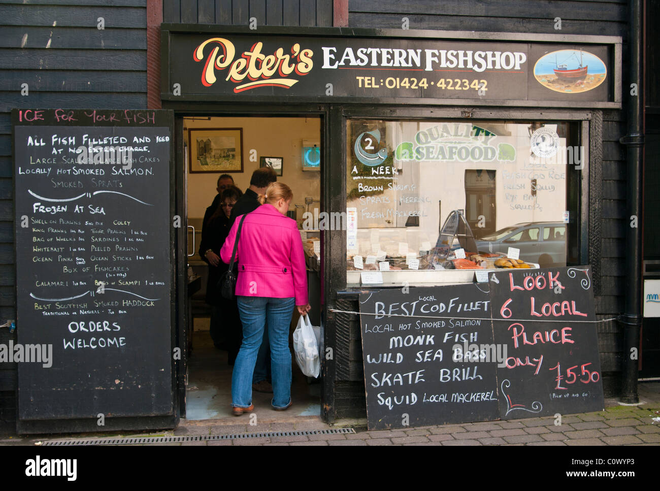 Kunden, die Schlange In ein Fischhändler Hastings East Sussex England Stockfoto