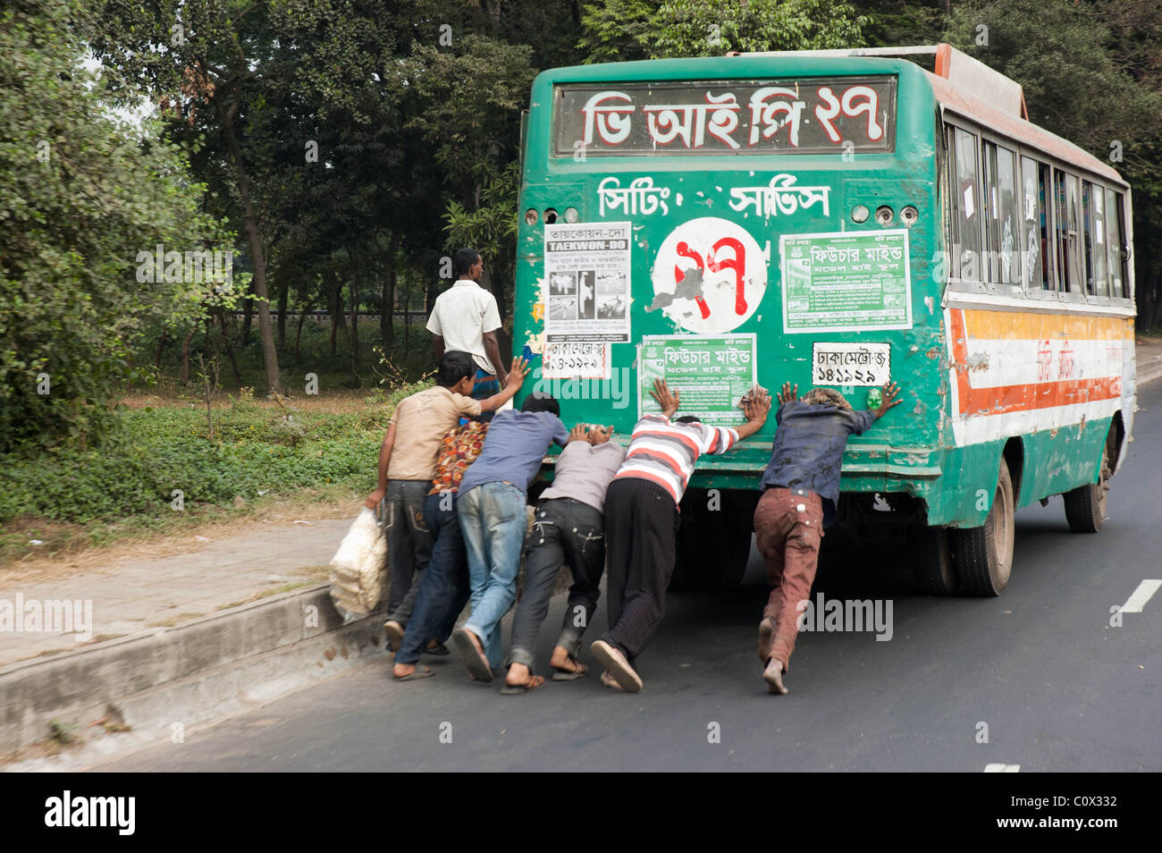 Eine Gruppe von Menschen herunterdrücken, einen gebrochenen Bus entlang der Autobahn von Chittagong, Bangladesh Stockfoto