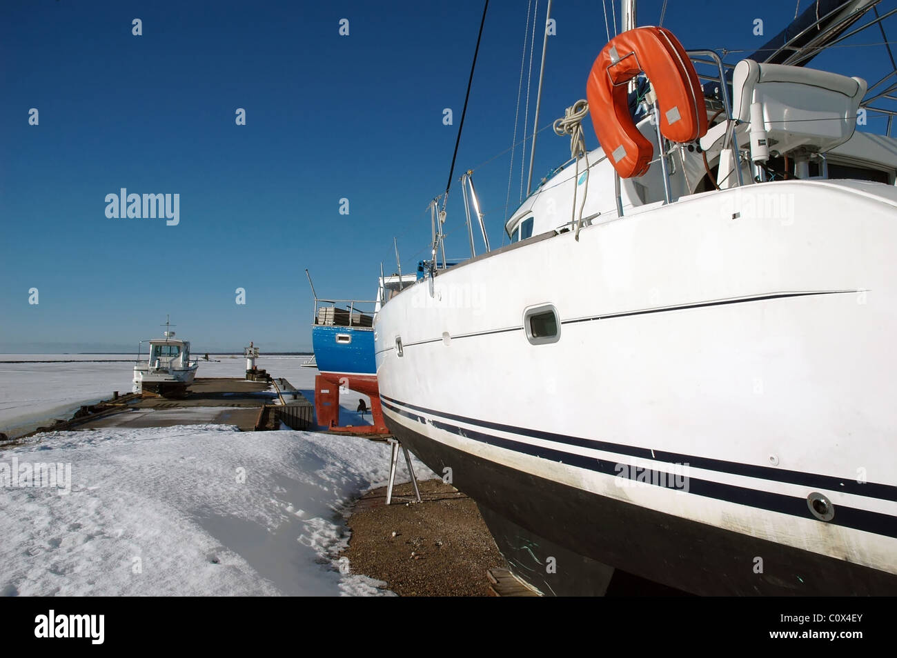 Yacht im Winter am zugefrorenen Hafen in Orjaku, Kassari, Hiiumaa, Estland Stockfoto