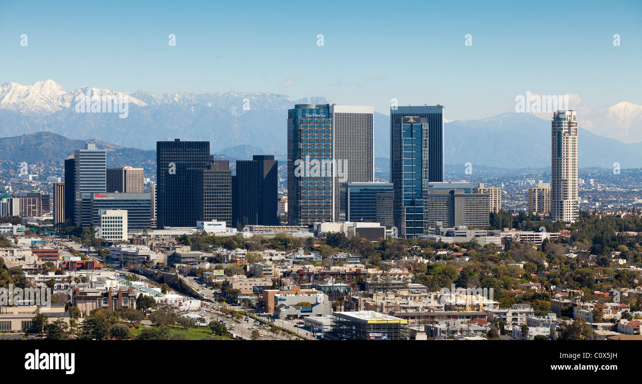 Skyline von Century City Gegend von Los Angeles nach einem Wintersturm mit Schnee in den Bergen im Hintergrund. Stockfoto