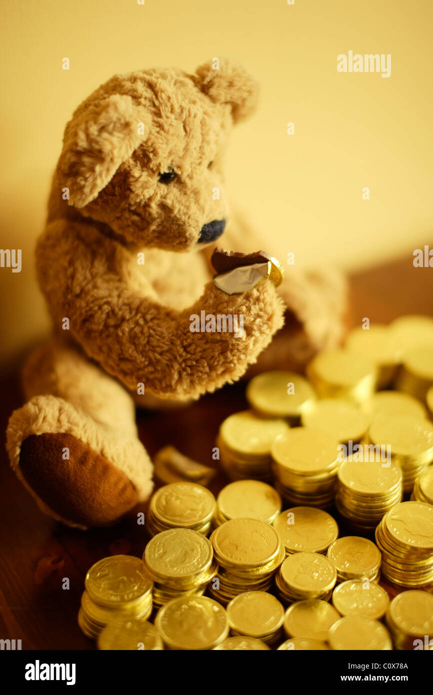 Ted steckt in seiner Schokolade Goldmünze Investition. Stockfoto