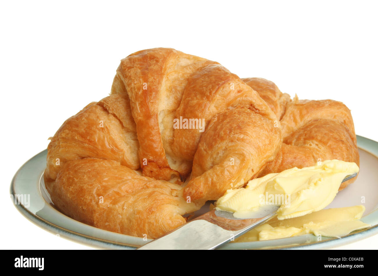 Nahaufnahme von Croissants mit Butter und ein Messer auf einem Teller Stockfoto