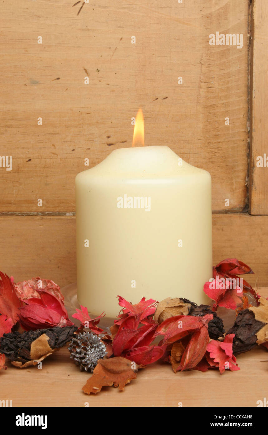 Brennende Kerze und Potpourri gegen eine alte Kiefer-Platte Stockfoto