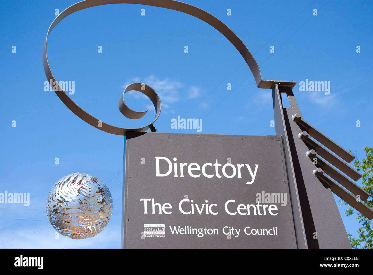 Silberne Kugel, die über Wellington Civic Square, mit Verzeichnis-Schild hängt. Wellington, Neuseeland Stockfoto