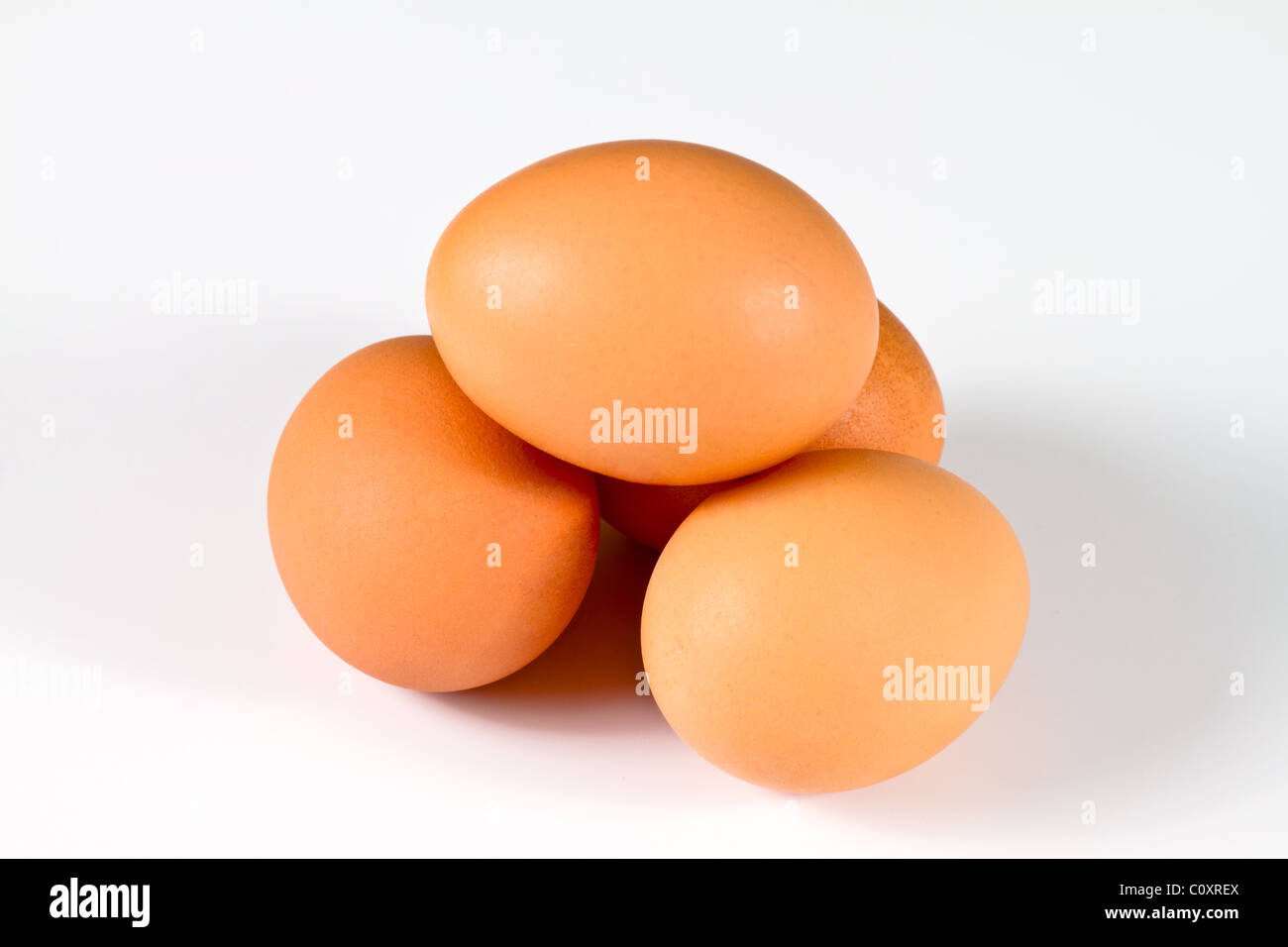 Vier braunen Eiern angeordnet wie ein Dolmen, isoliert auf weißem Hintergrund Stockfoto
