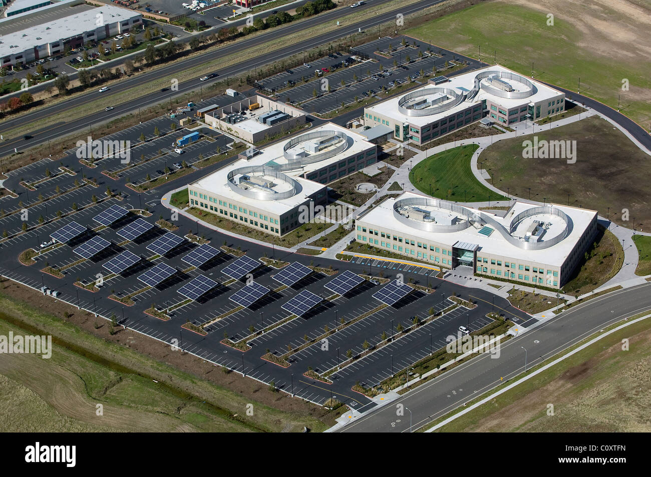 Luftaufnahme über Sonnenkollektoren platziert in Parkplatz kommerziellen Bürogebäude Vacaville, Kalifornien Stockfoto