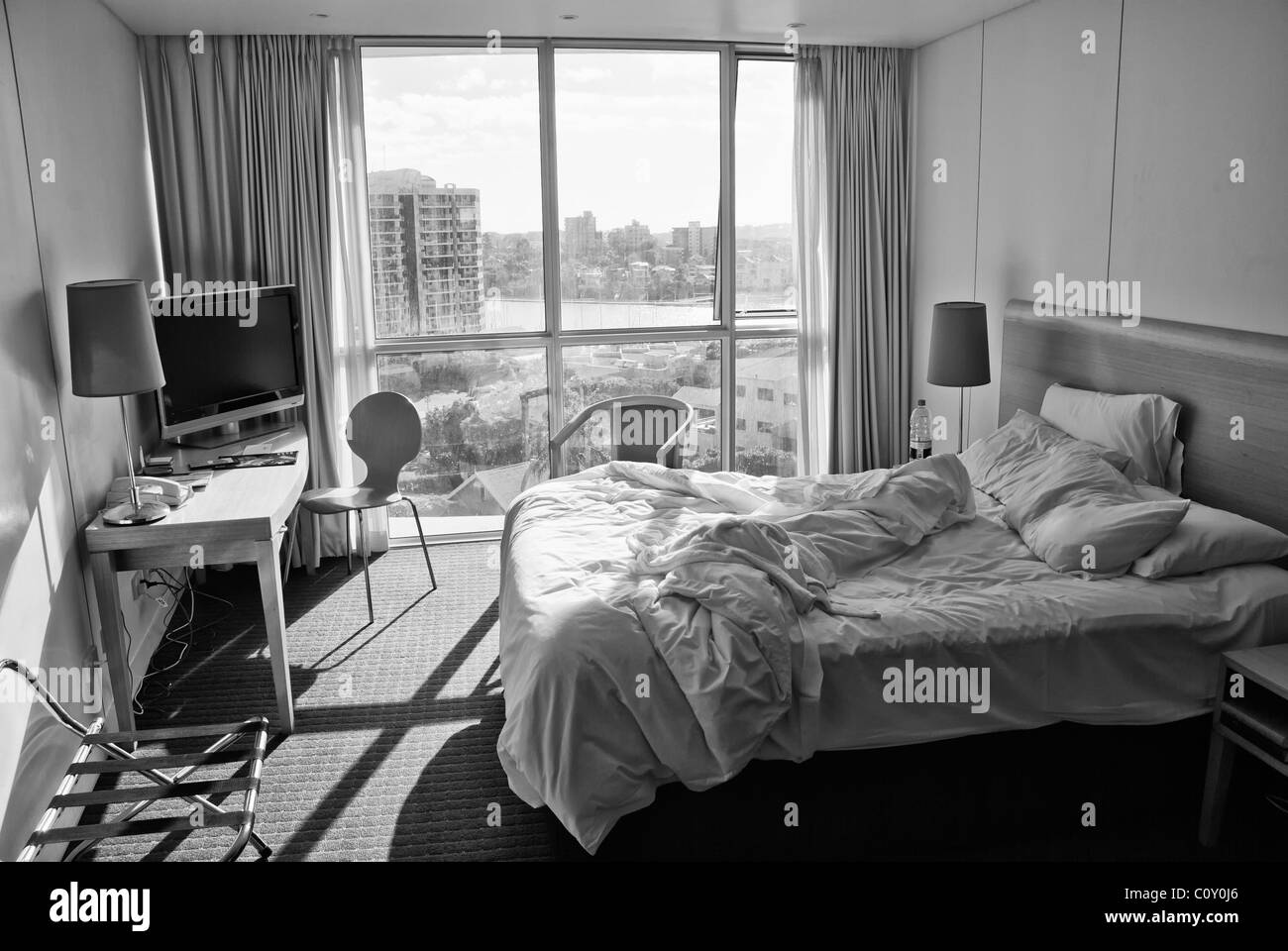 Hotelzimmer mit ungemachten Bett und City View, Australien Stockfoto