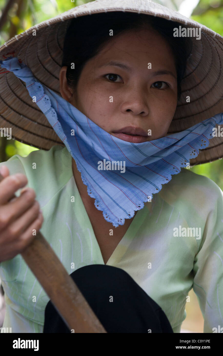 Porträt einer Frau mit Paddel in einem Boot auf einem Kanal, Mekong Delta, Vietnam, Asien Stockfoto