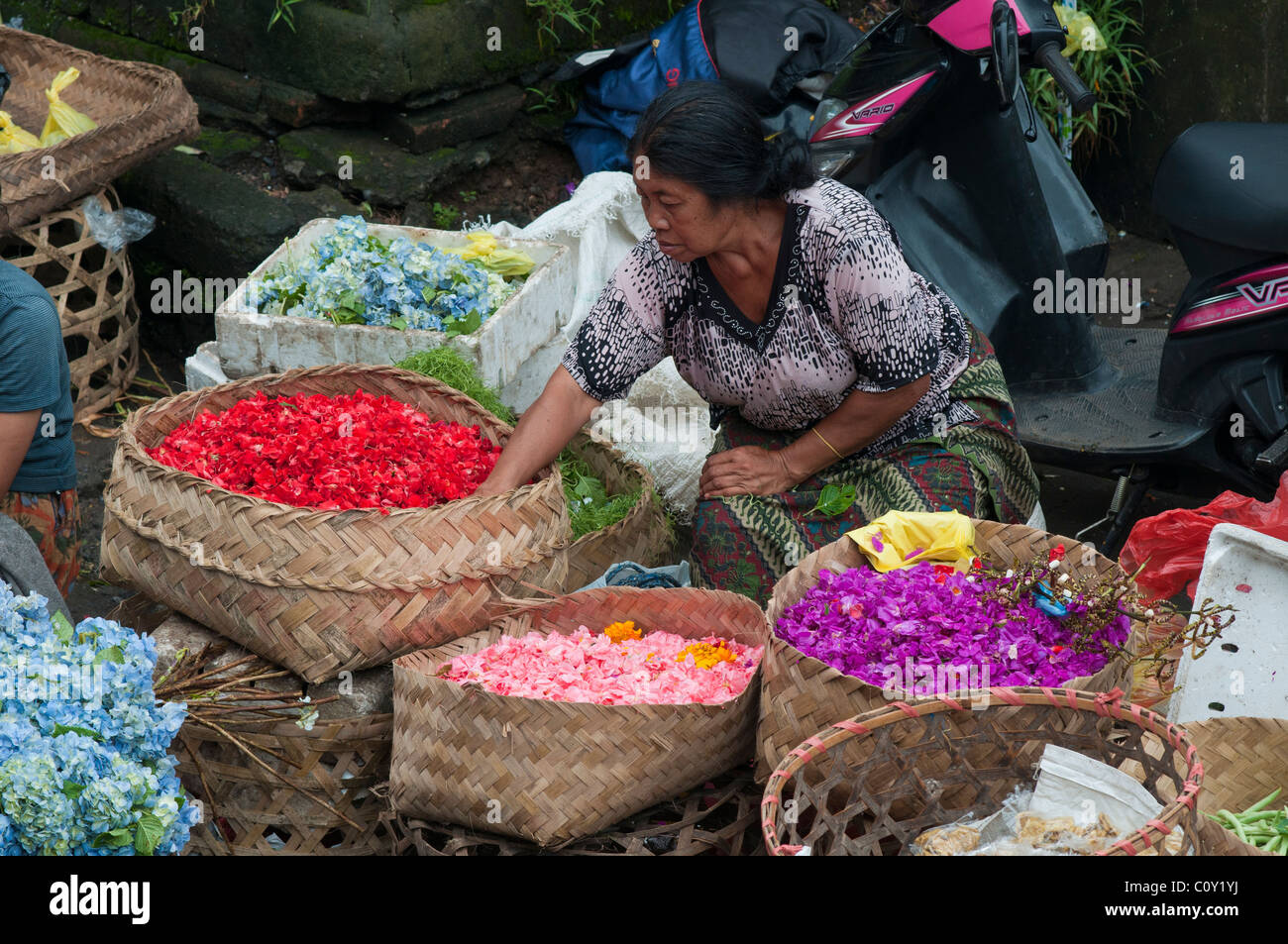 Frau verkaufen Blütenblätter für die Herstellung von Angeboten auf dem Markt in Ubud Bali Indonesien Stockfoto