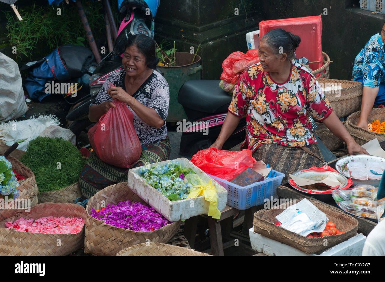 Frau verkaufen Blütenblätter für die Herstellung von Angeboten auf dem Markt in Ubud Bali Indonesien Stockfoto