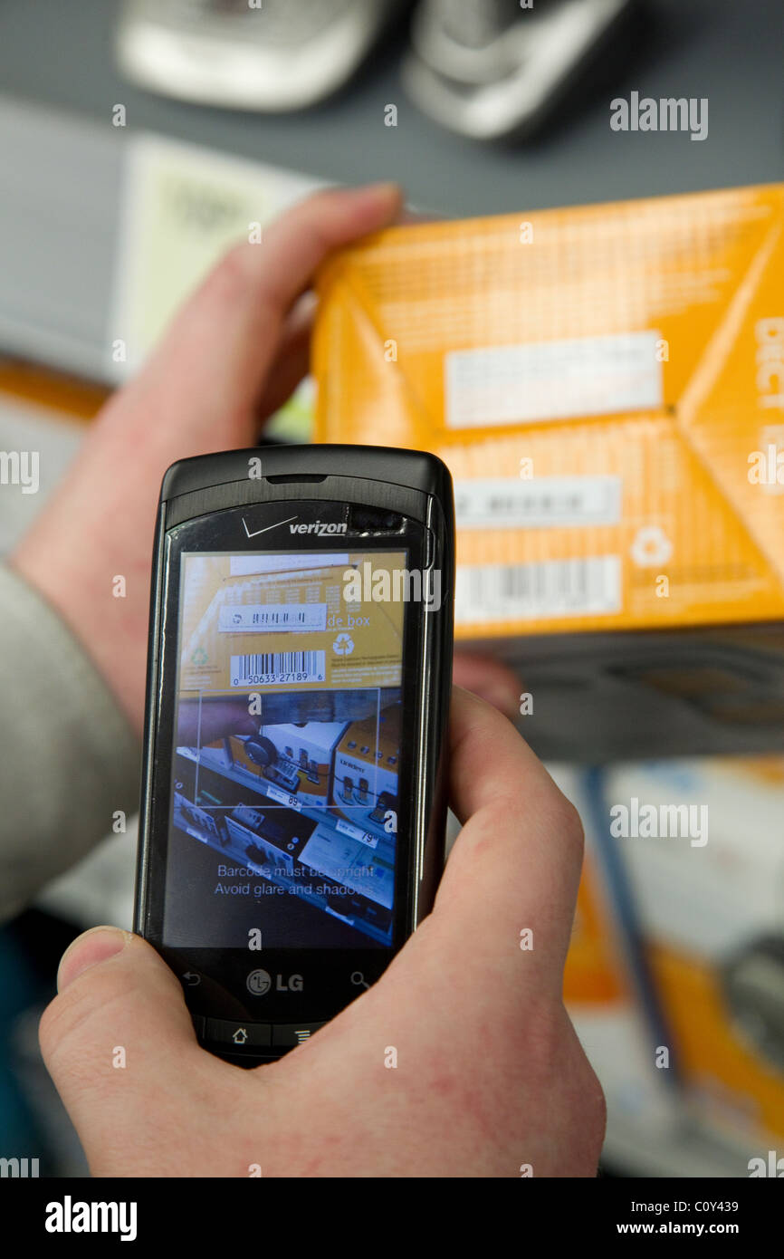 Person mit TheFind Smartphone app auf Verizon Smartphone Scannen UPC-Codes im Store Preis überprüfen Stockfoto