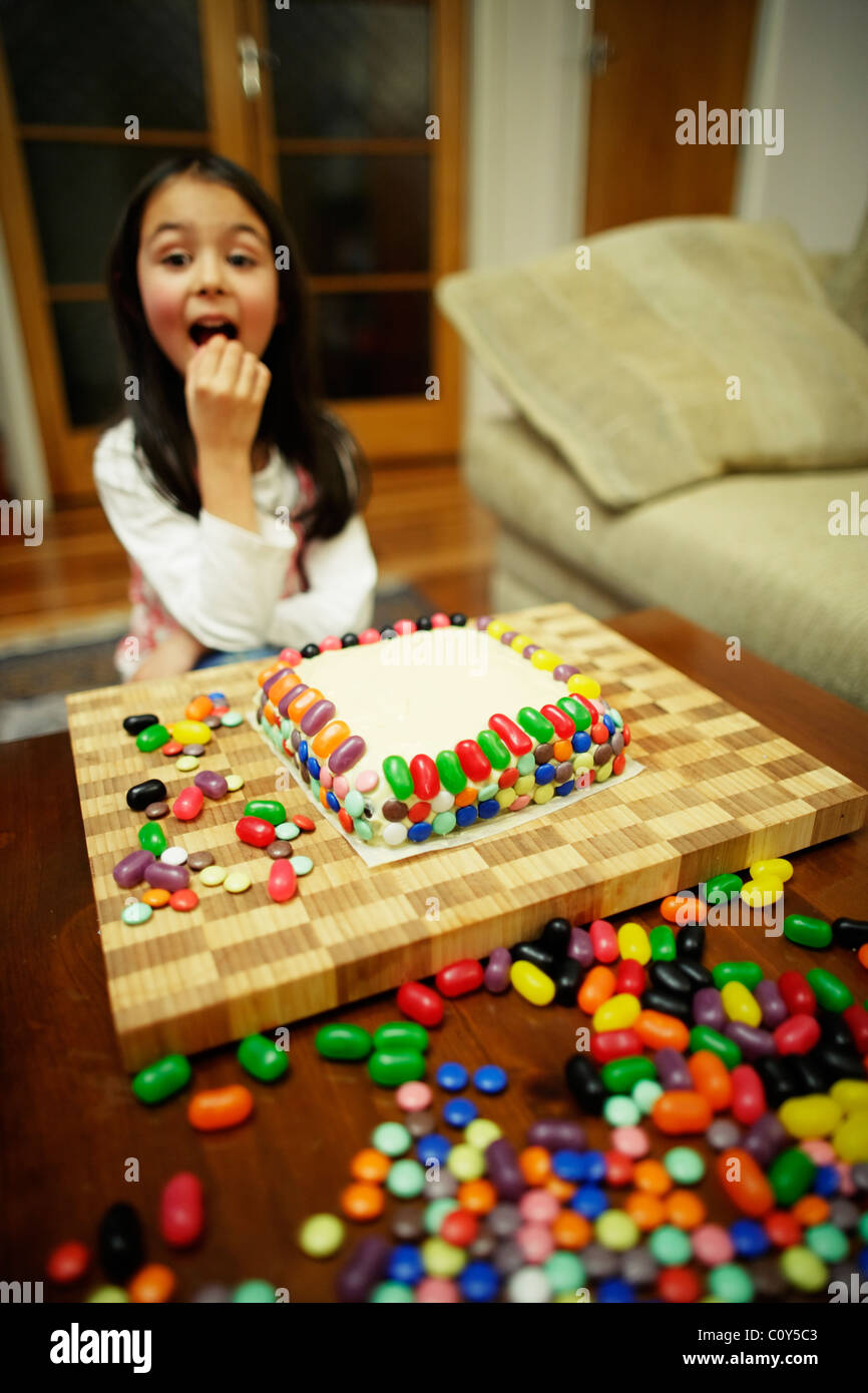 Mädchen schmücken ihre Geburtstagstorte Stockfoto