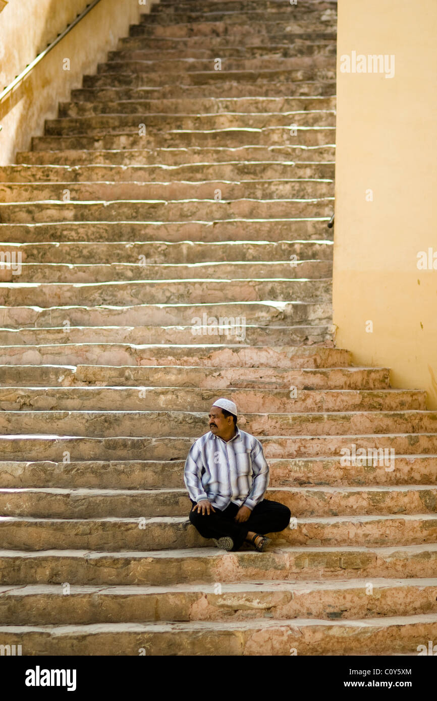 Indischen Mann sitzt allein auf lange Schritte in Amber Fort in Jaipur Stockfoto