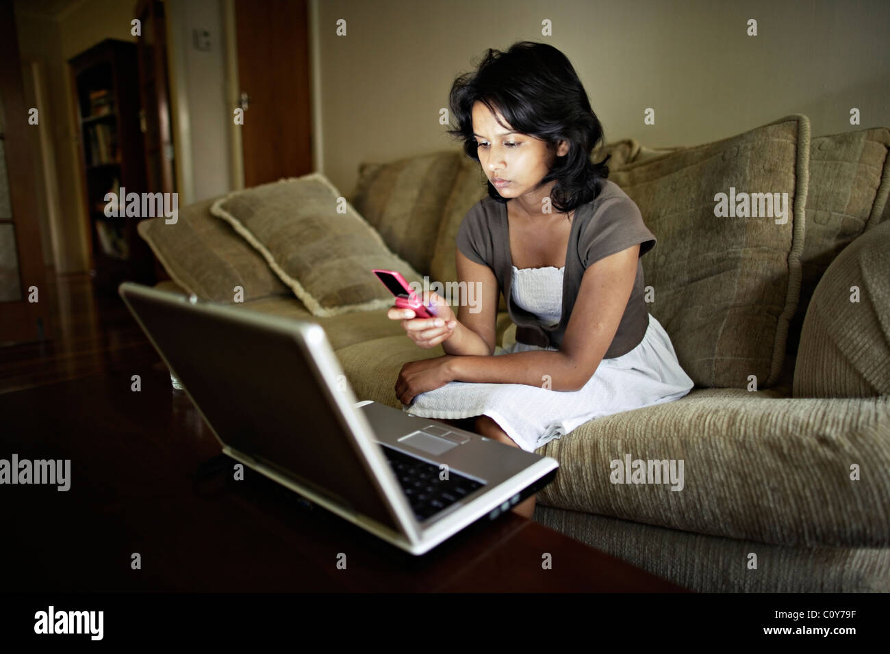 Frau mit Laptop und Handy Stockfoto