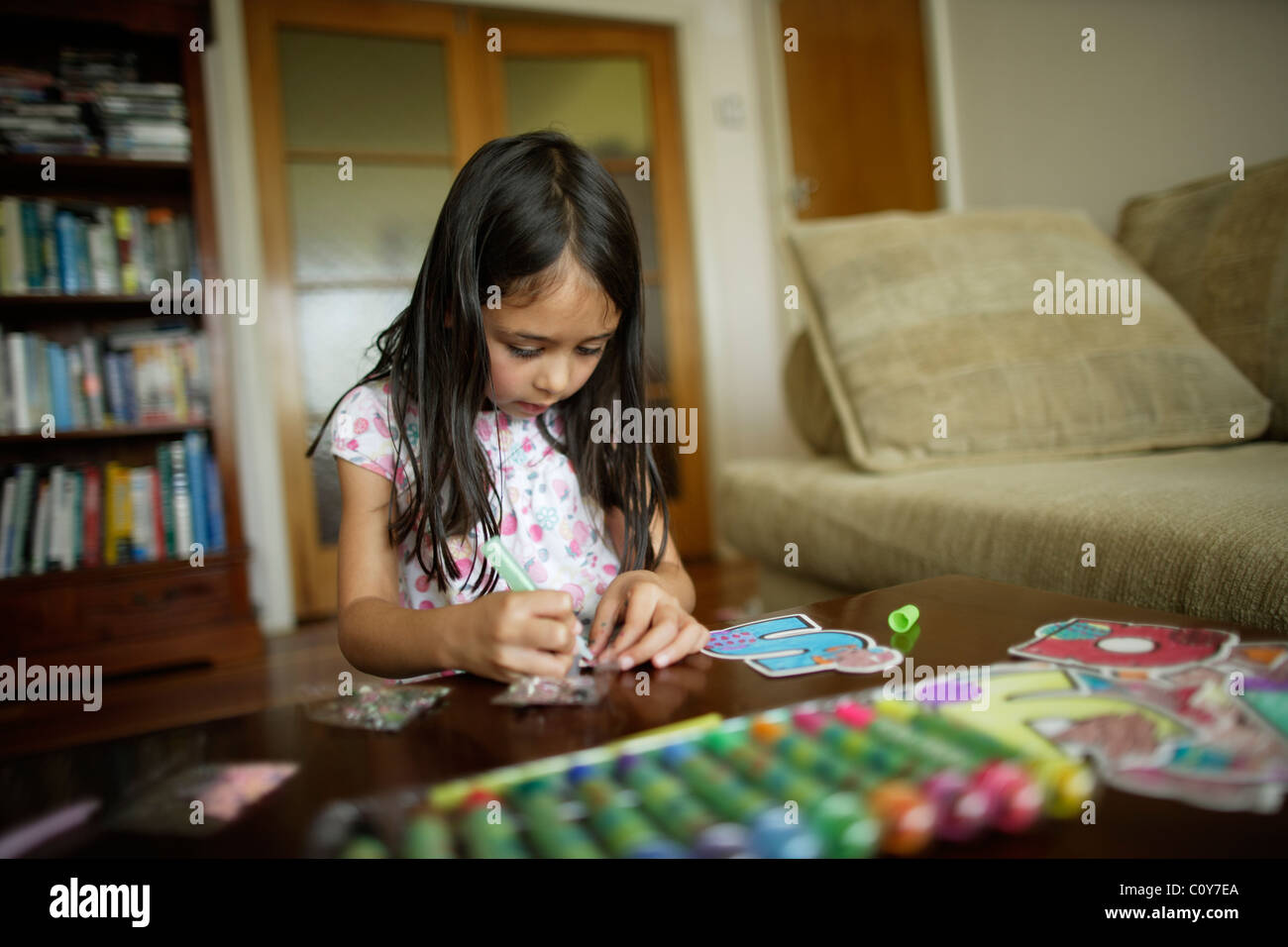 Sechs Jahren arbeitet altes Mädchen am Handwerk Set großer Buchstaben zu malen und dekorieren Stockfoto