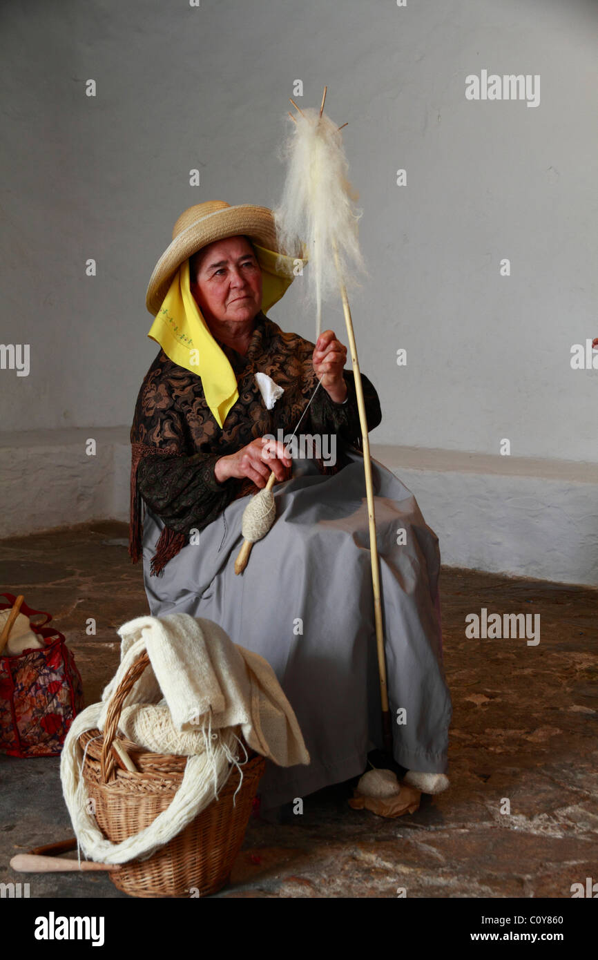 Ältere Dame in Tracht Spinnen Wolle auf ein Handwerk Messe, Ibiza, Spanien Stockfoto