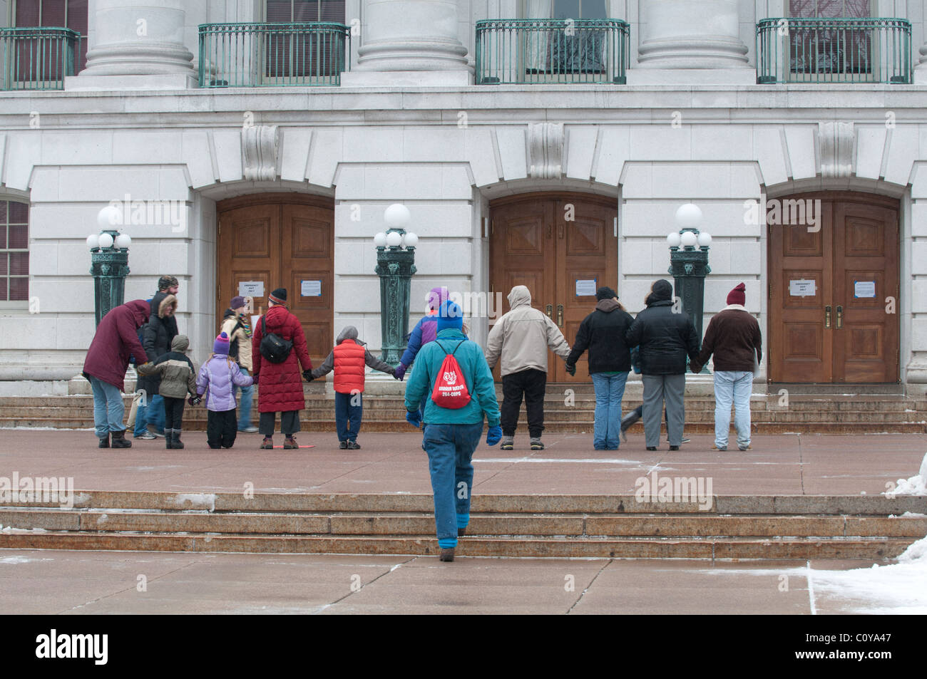 Demonstranten halten Hände um des Kapitols in Madison, Wisconsin, eingeführt von Scott Walker Entwurf des Haushaltsplans zu kämpfen. Stockfoto