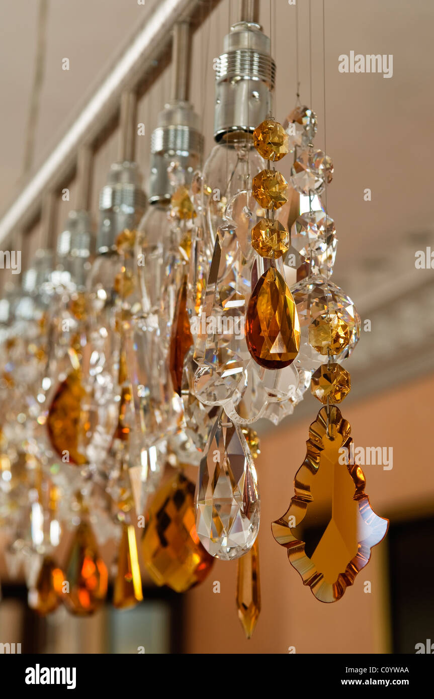 Detail der zeitgenössischen Beleuchtung mit exponierten Glühbirne und Glas-Kronleuchter-Anhänger Stockfoto