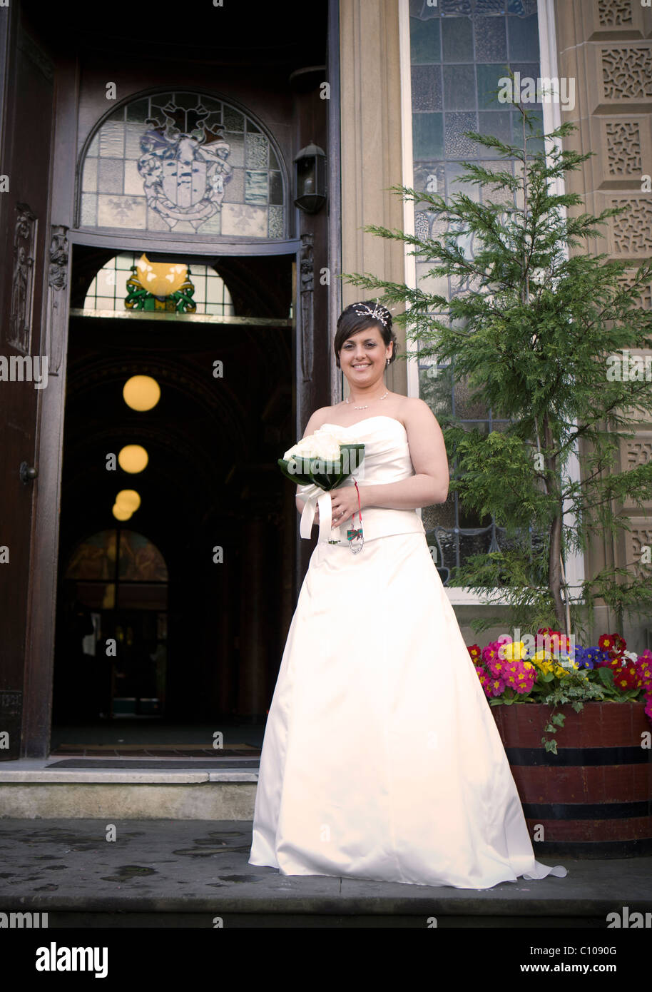 FRISCH VERHEIRATET FRAU POSIEREN FÜR FOTOS BEI IHRER REGISTRY OFFICE HOCHZEIT Stockfoto