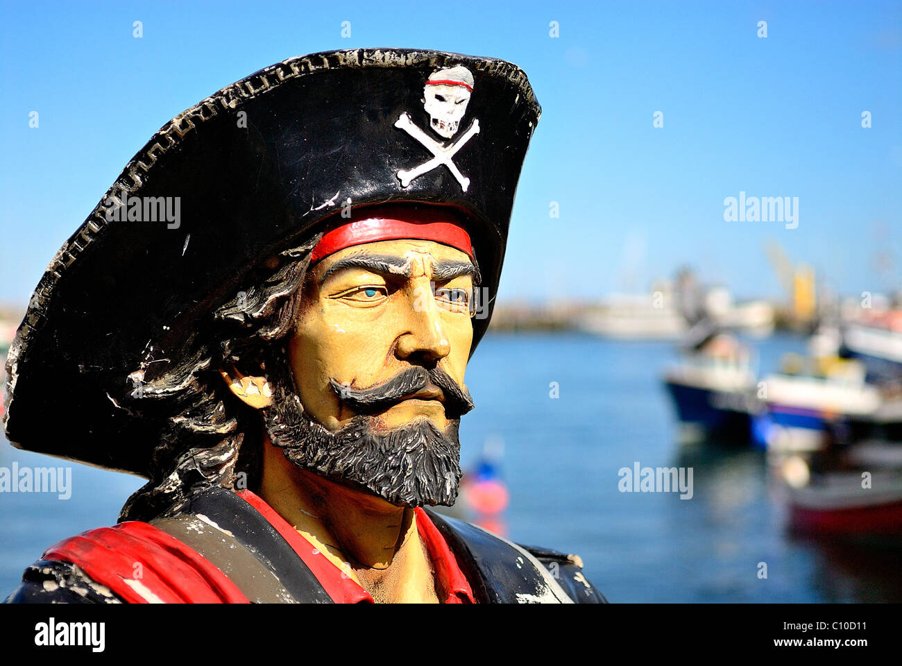 Eine Statue von ein Alter bärtiger Meer Pirat Blick auf das Meer in Scarborough mit strahlend blauem Himmel und Boote im Hintergrund Stockfoto