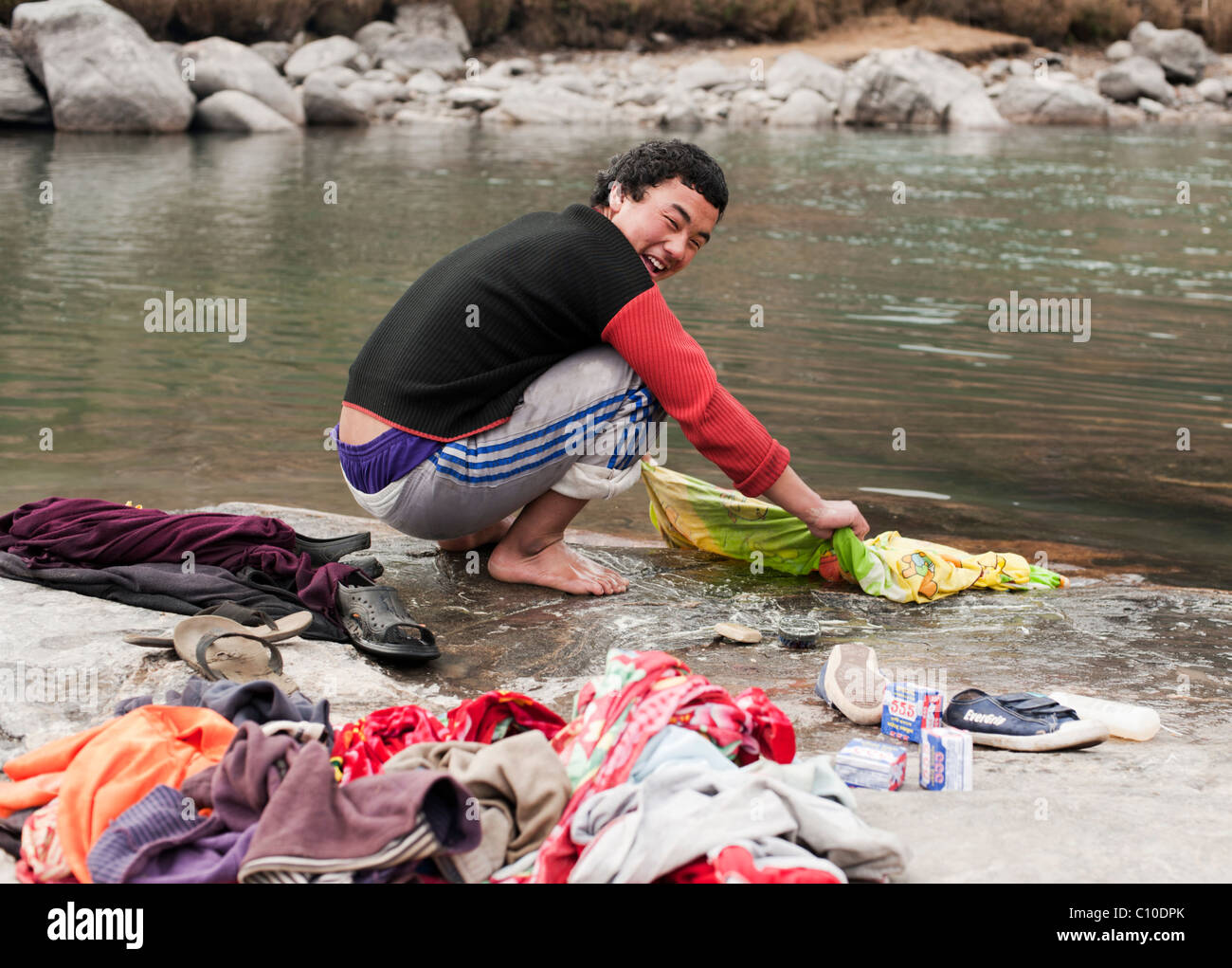 Bhutan junge Wäsche in einem Fluss in Bumthang, Bhutan. Stockfoto