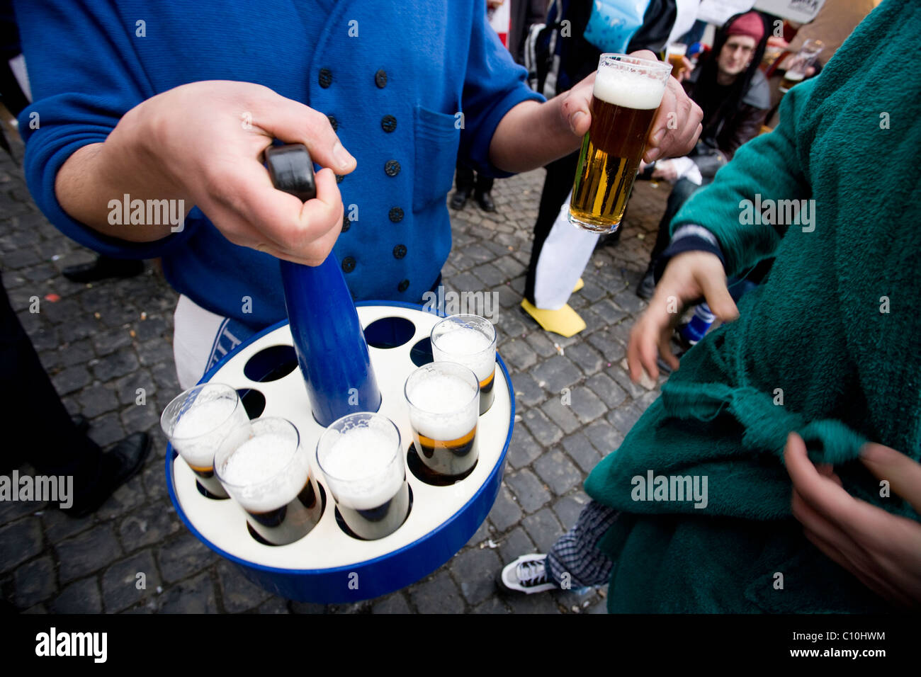 Ein Barkeeper dient Kölsch, typische Locar Bier, während verrückte Tage Karneval in Köln. Stockfoto