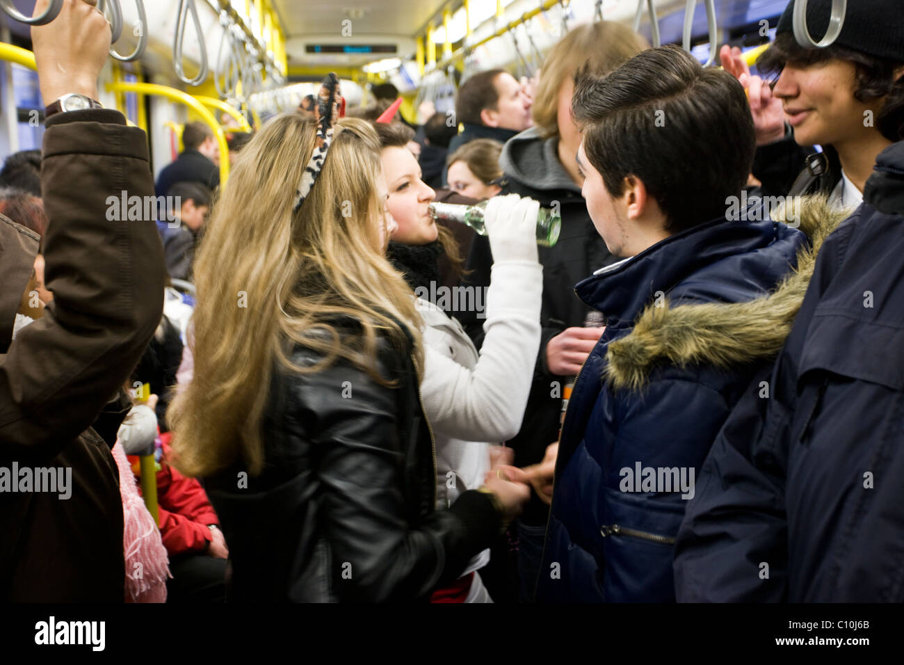 Jugendliche trinken in öffentlichen Verkehrsmitteln, während des Karnevals in Köln. Stockfoto