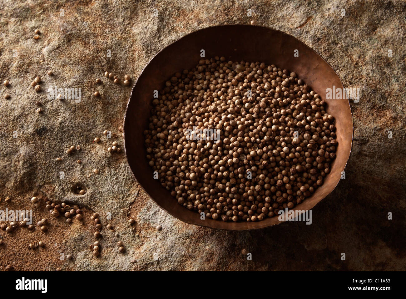 Koriander (Coriandrum Sativum) in einer kupfernen Schüssel auf eine Steinoberfläche Stockfoto