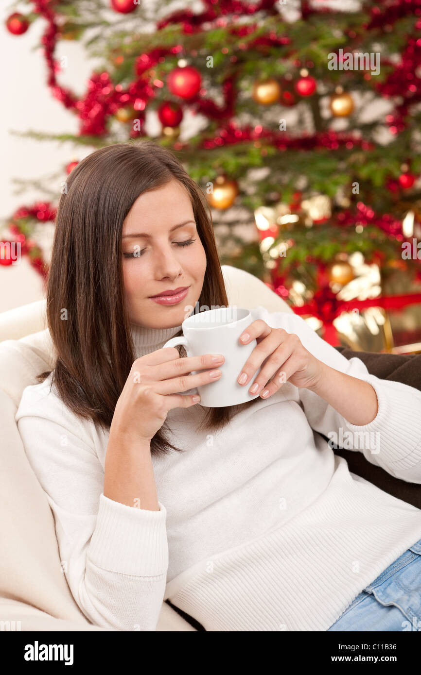 Braune Haare Frau entspannend mit Kaffee auf Weihnachten vor Weihnachten Baum Stockfoto