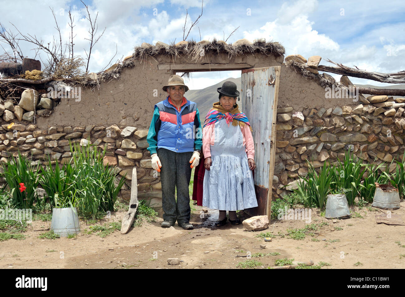 Porträt von zwei ältere Leute, paar, in einem Hof Tor bolivianischen Altiplano Hochland, Departamento Oruro, Bolivien, Südamerika Stockfoto