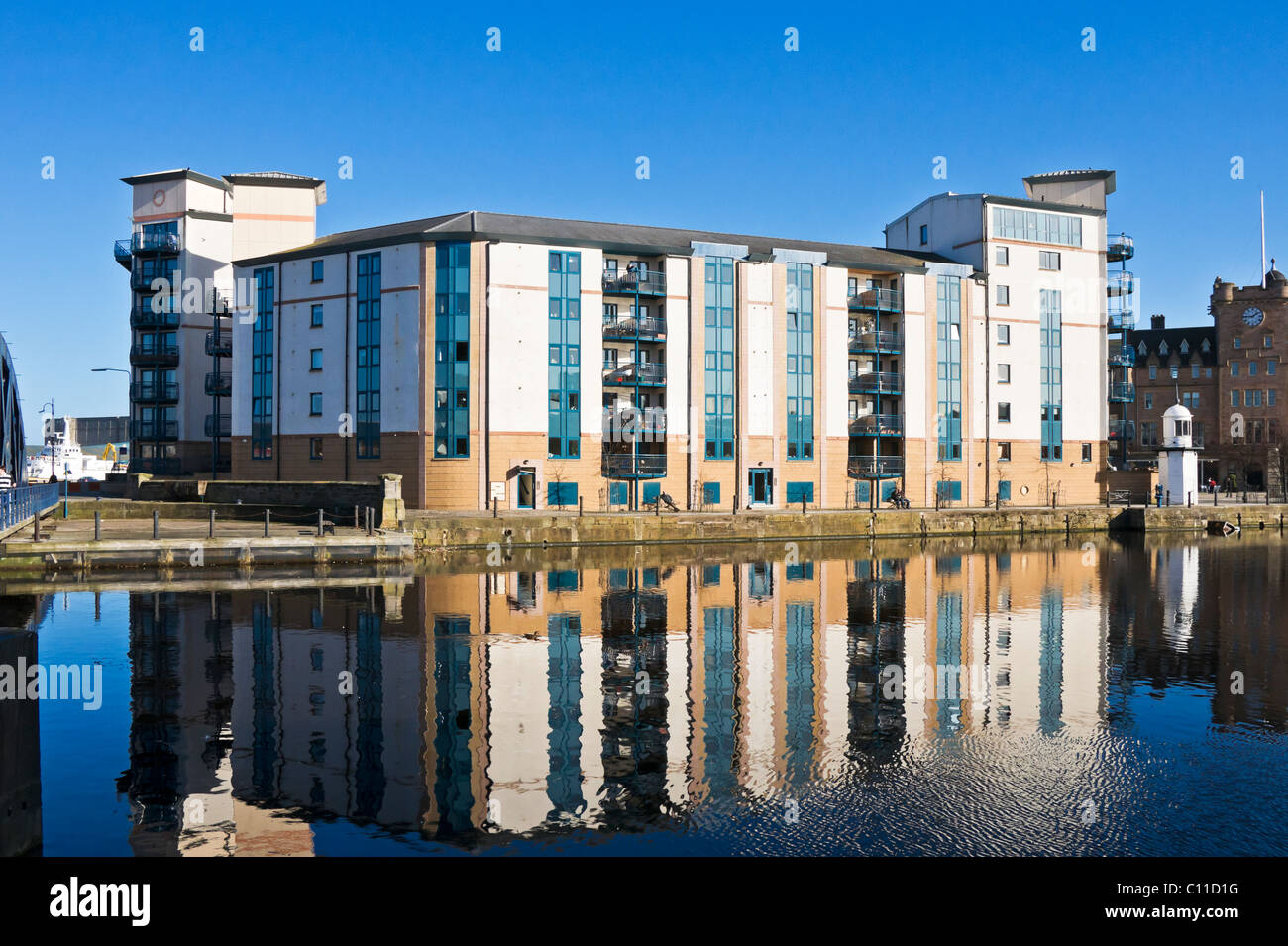 Appartementhaus und Leuchtturm (links) auf der Küste von Queen es Dock in Leith Docks Edinburgh Schottland Stockfoto