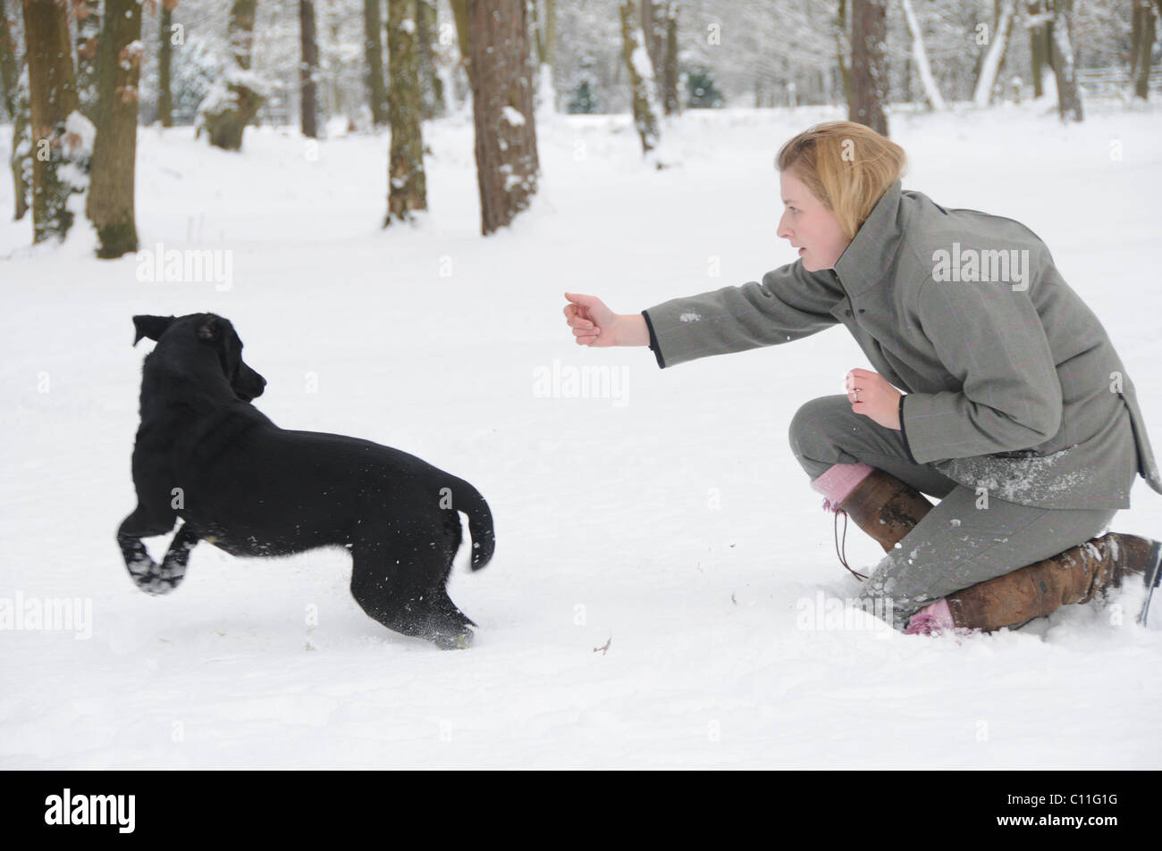 Mädchen in Tweed Kommissionierung bis auf ein Shooting im Schnee Stockfoto