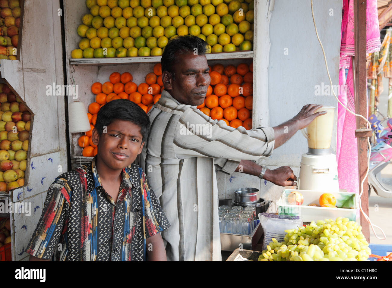 Vater und Sohn in einem Obstladen mit Saft Mixer, Punjaipuliampatti, Tamil Nadu, Tamil Nadu, Südindien, Indien, Südasien, Asien Stockfoto