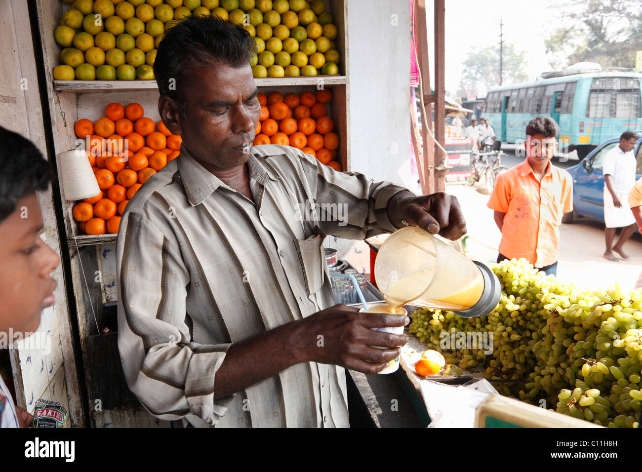 Obst Verkäufer Gießen frisch gepressten Orangensaft in Tasse, Punjaipuliampatti, Tamil Nadu, Tamil Nadu, Südindien, Indien, Südasien, Asien Stockfoto