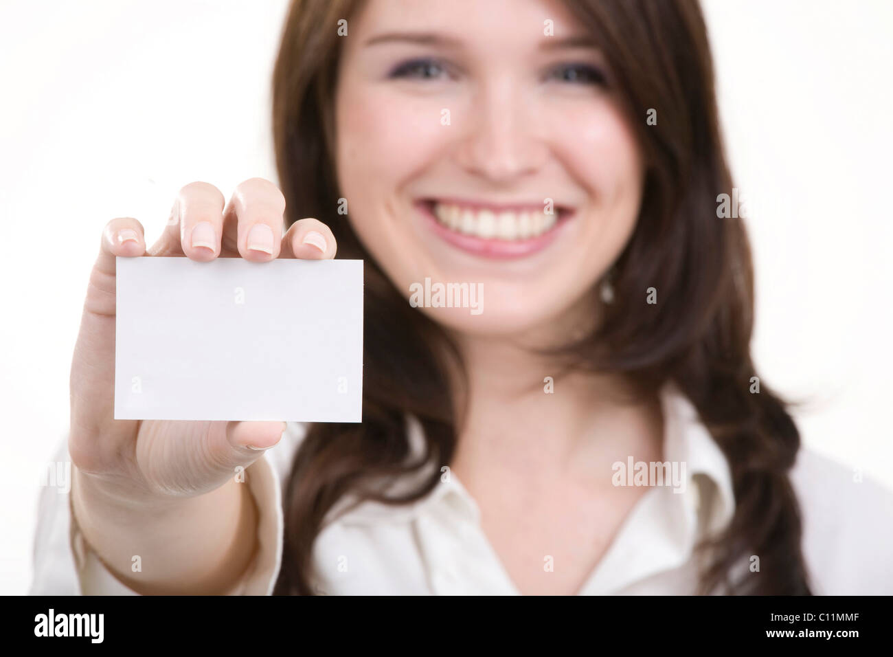 Lächelnde junge Frau mit einer Visitenkarte Stockfoto