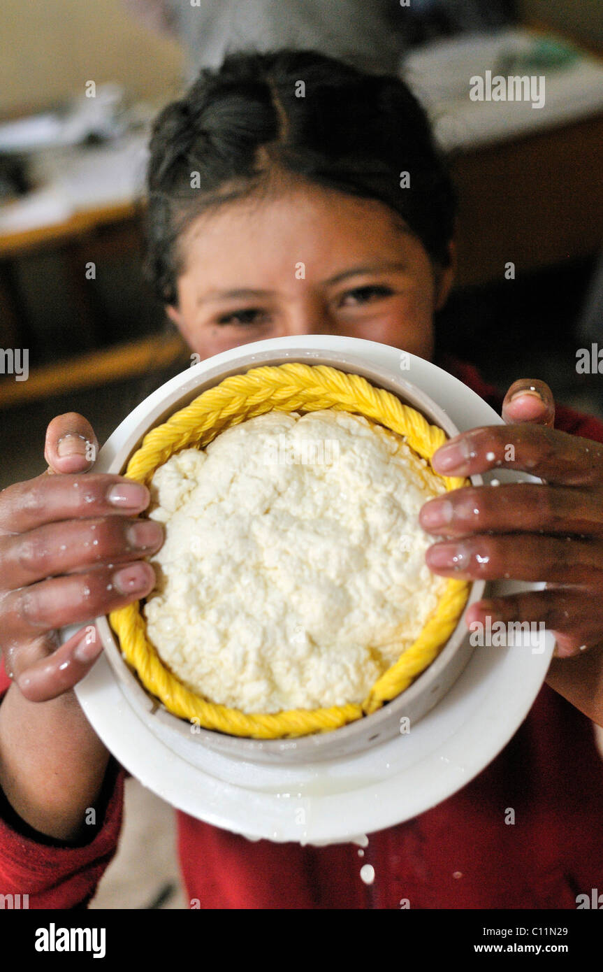 Herstellung von Frischkäse im Tal Penas, präsentiert junges Mädchen Lachen Käse in runder Form gepresst Departamento Oruro Stockfoto