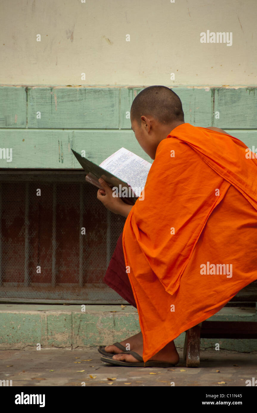 Myanmar (aka Burma), Mandalay, Amarapura. Mahagandayone Kloster, das größte Kloster in Myanmar. Mönch zu lesen. Stockfoto