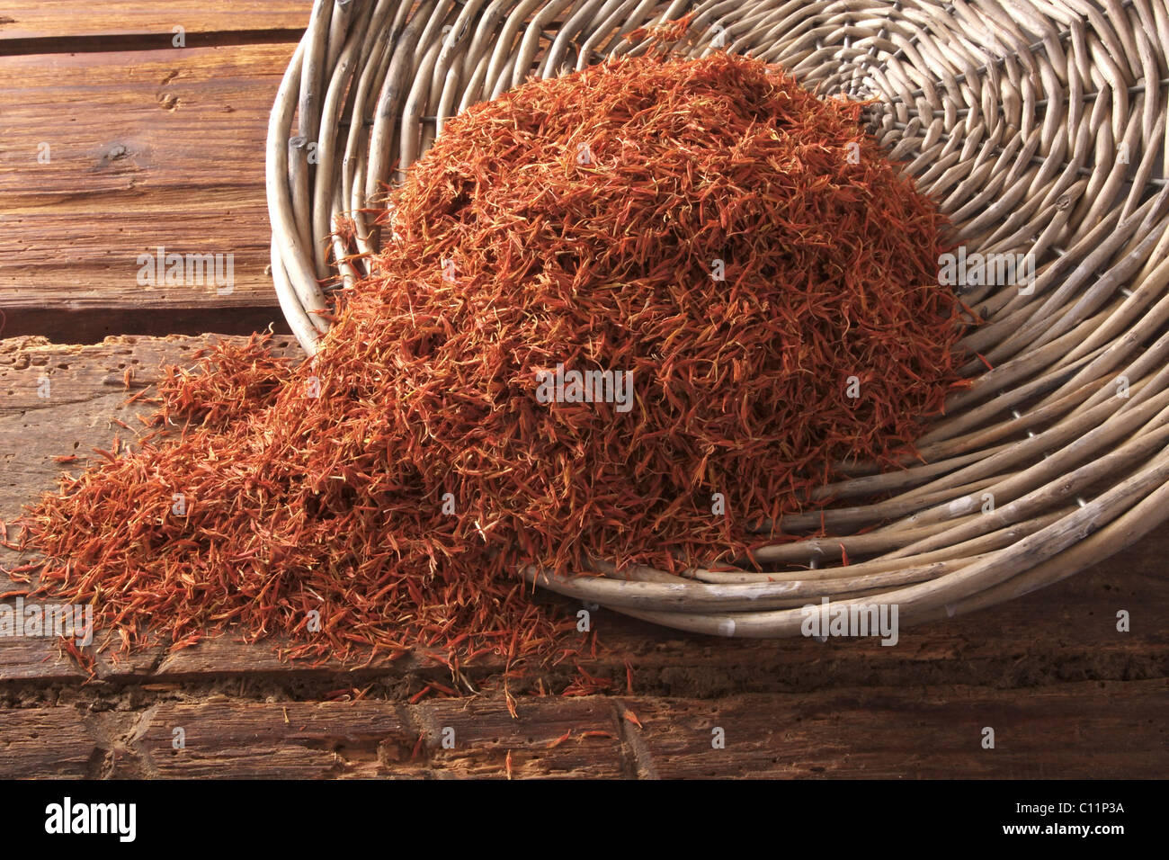 Distelöl (Carthamus Tinctorius), als Tee oder Lebensmittelfarbe, Safran Ersatz aus einer Weide Korb gekippt Stockfoto
