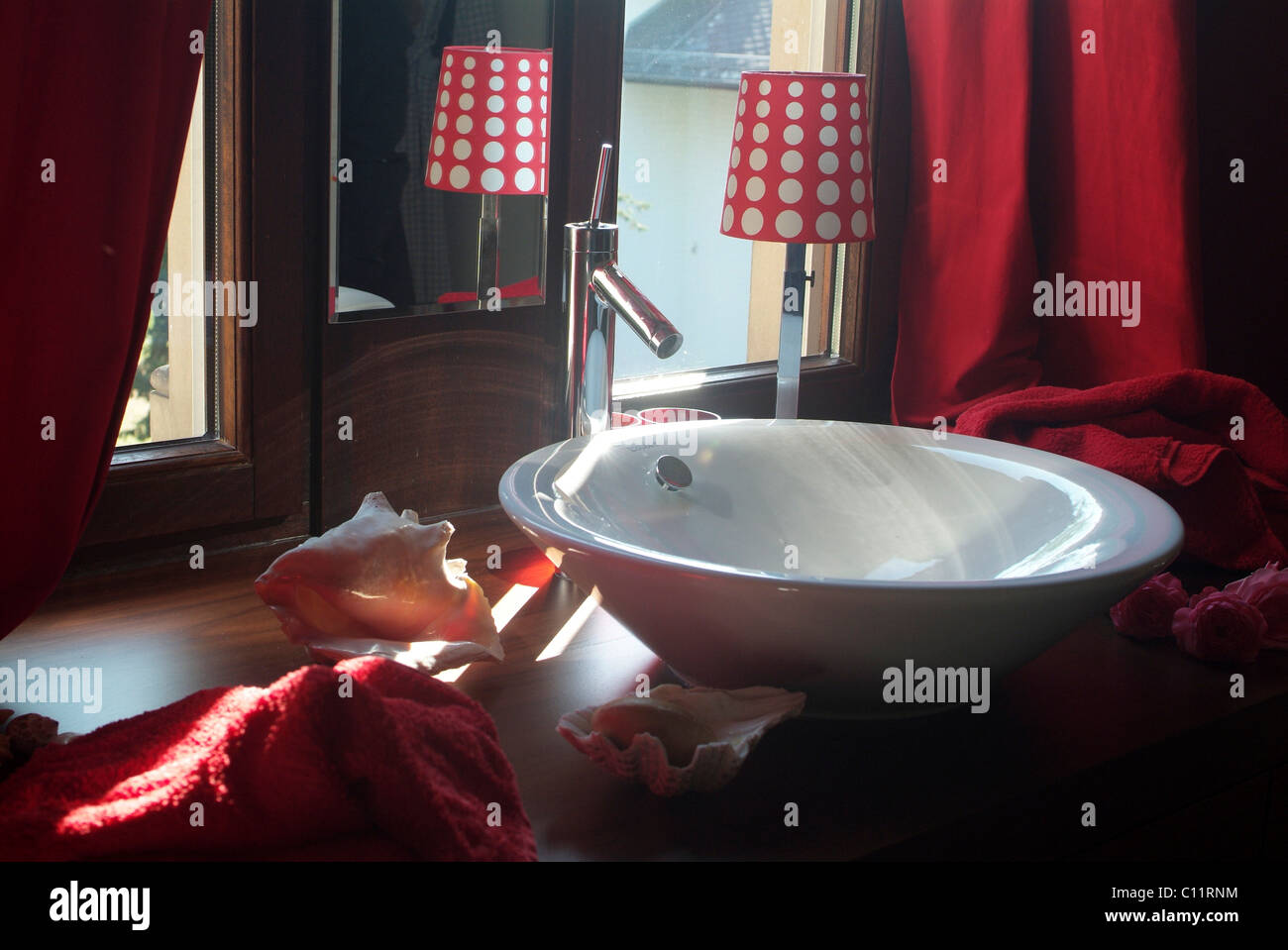Becken eines Badezimmers verziert mit Muscheln, anspruchsvolles, modernes Design und stimmungsvolle Beleuchtung Stockfoto