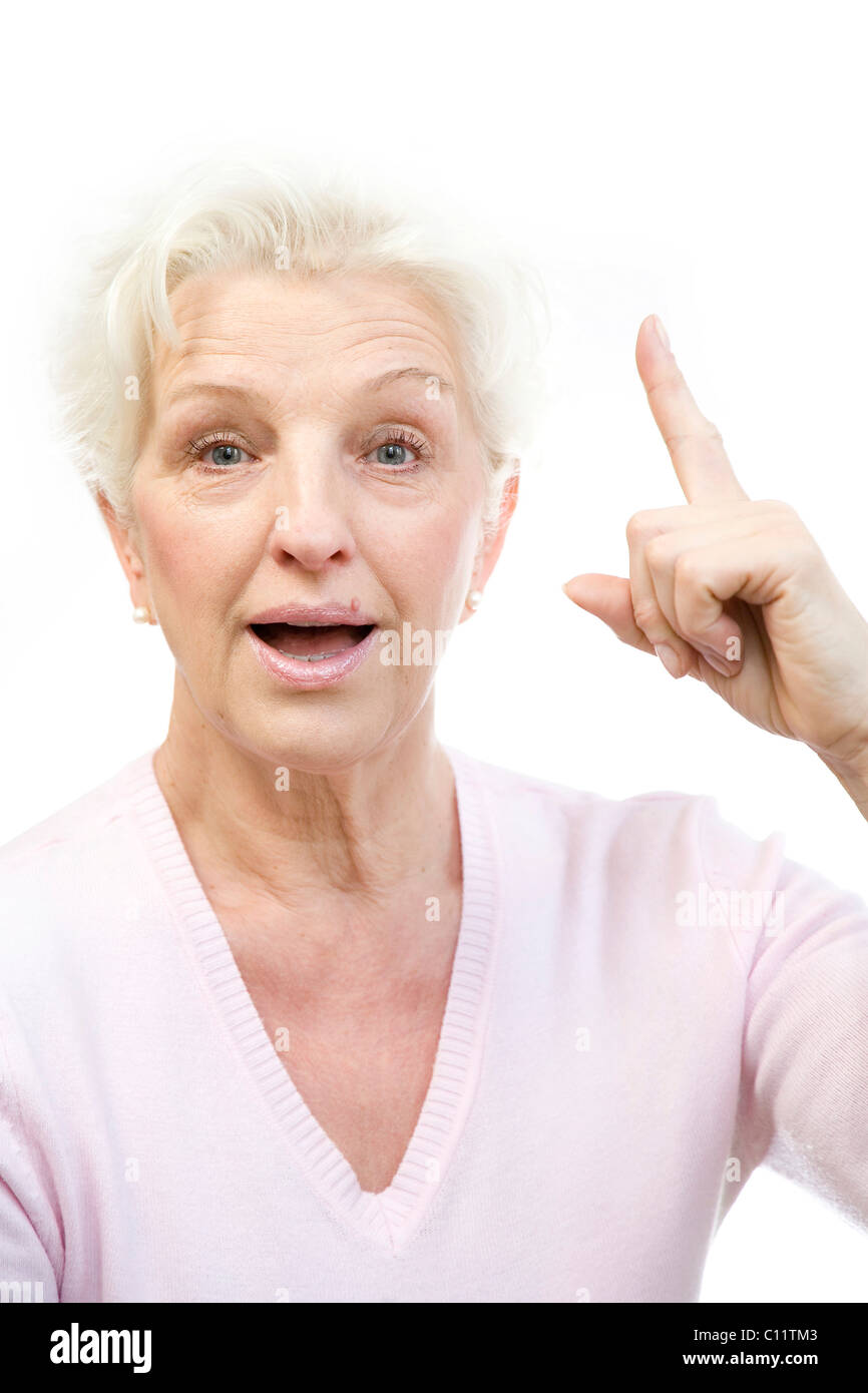Ältere Frau, die eine plötzliche Eingebung nach oben Zeigefinger Stockfoto