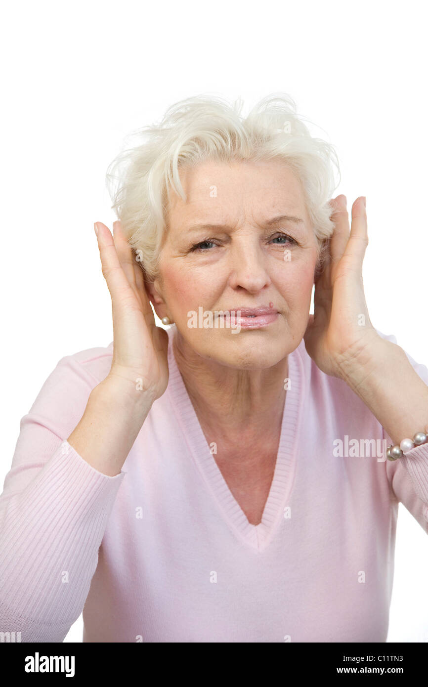 Alte Frau für ihre Ohren mit beiden Händen Stockfoto