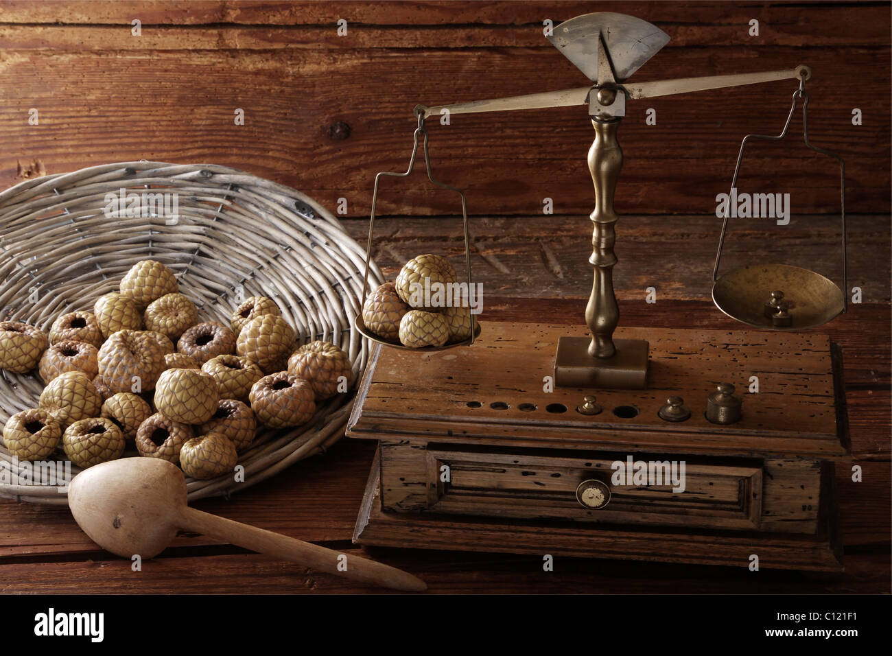 Antike Skalen mit einem Gewicht von Salak oder Snake Fruit (Salacca Zalacca) auf eine Holzoberfläche Stockfoto