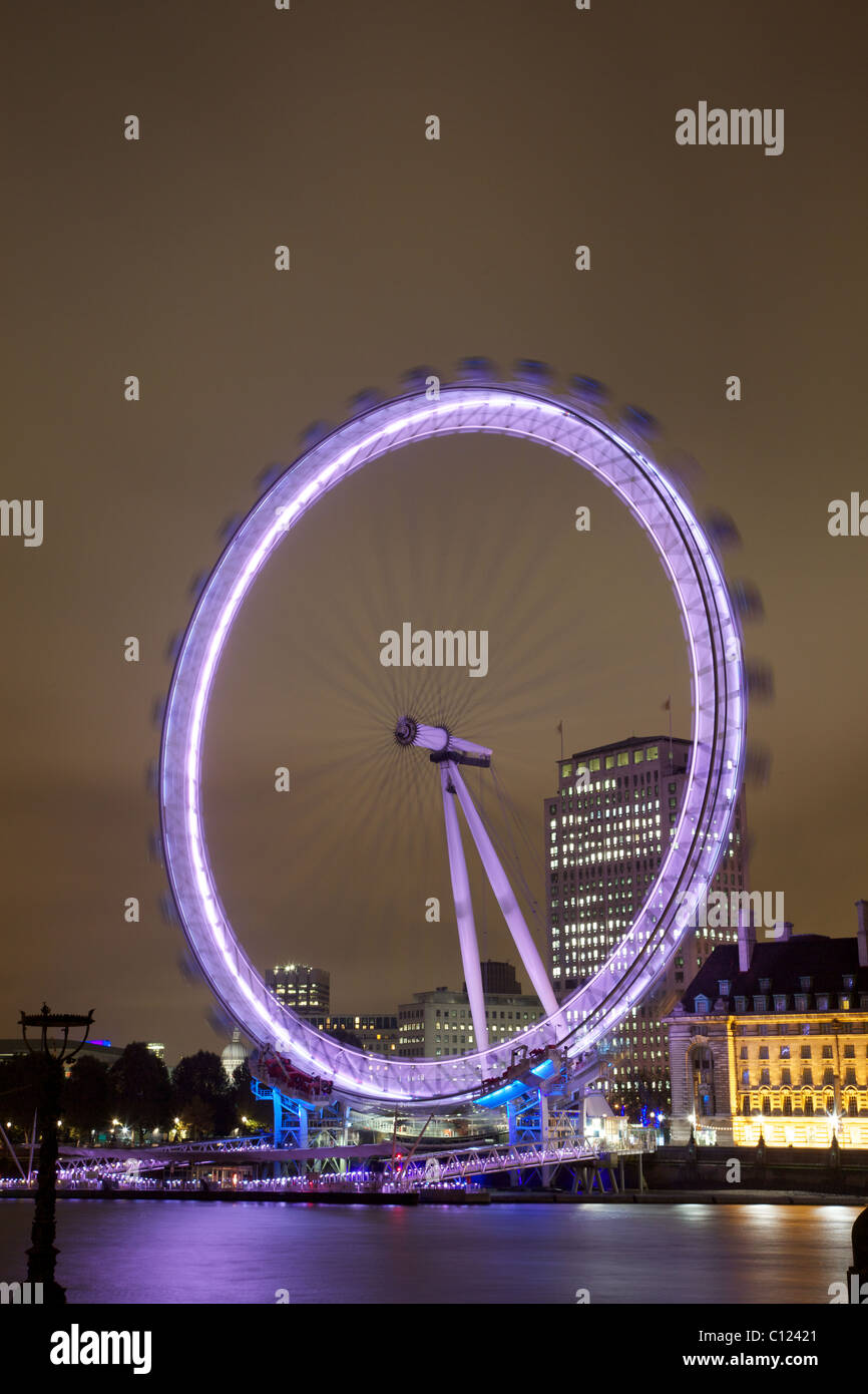 Das London Eye in der Nacht. Eine Langzeitbelichtung gibt ein Gefühl von Bewegung. Stockfoto