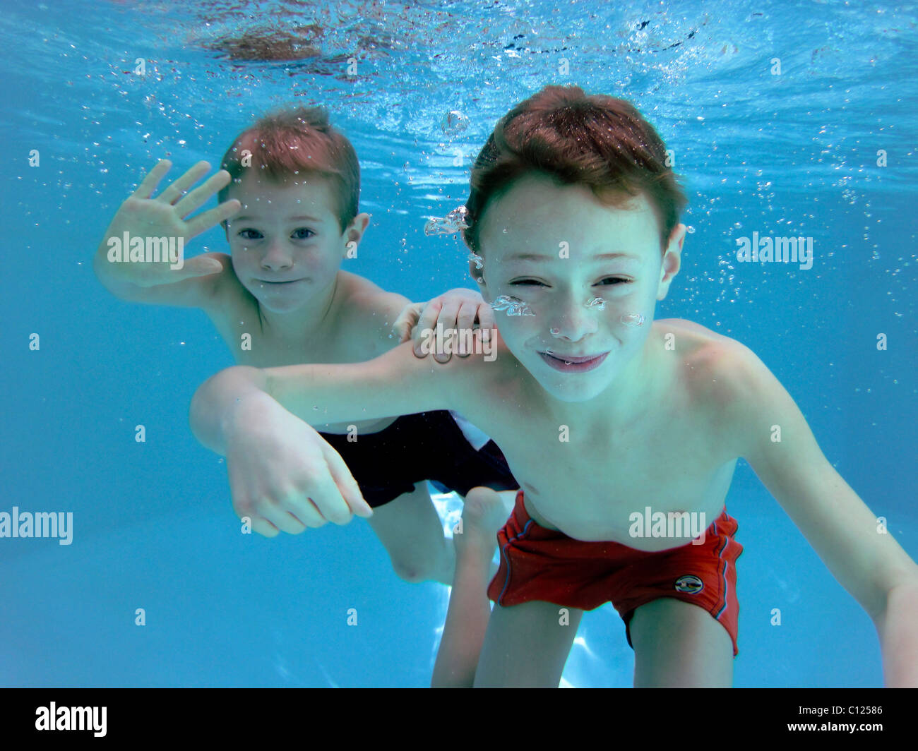 Zwei jungen, 6 und 7 Jahre alt, unter Wasser in einem pool Stockfoto